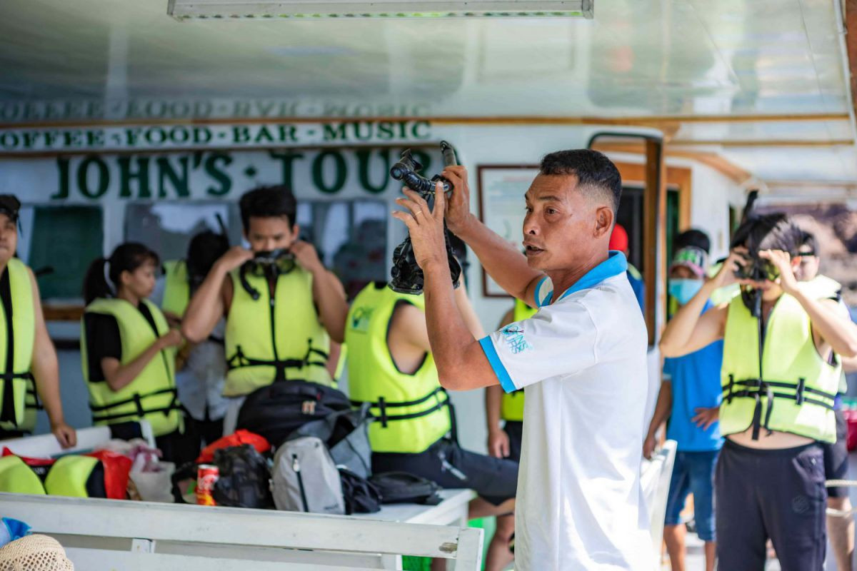 Hướng dẫn viên của John's Tours hướng dẫn khách cách sử dụng thiết bị lặn biển.